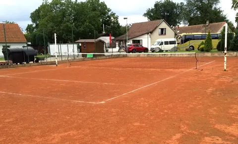 Antukový tenisový kurt se sítí v Březiněvsi, v pozadí restaurace a parkoviště
